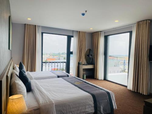 胡志明市Hera Luxury Hotel的一间卧室设有一张大床和大窗户