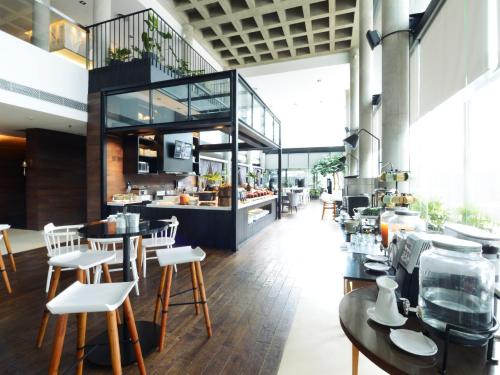 雅加达莫里西公寓式酒店的一间带桌椅和柜台的餐厅