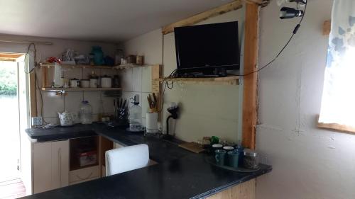 Plesumi的厨房配有台面,墙上配有电视