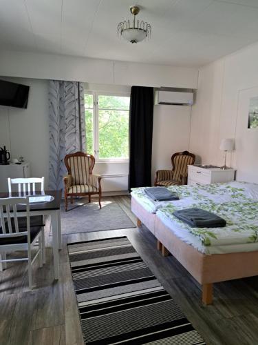普马拉Villa Saimaan Sydän的卧室配有一张床和一张桌子及椅子
