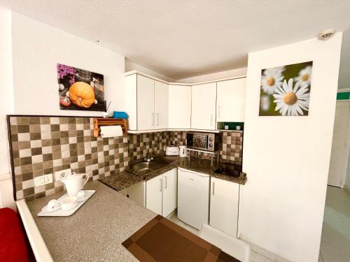 美洲海滩Borinquen Sky Apartments的一间小厨房,配有白色的橱柜和台面