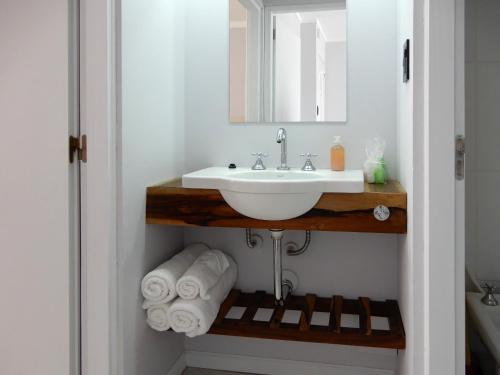 圣罗莎Edificio Parana的浴室配有盥洗盆、镜子和毛巾