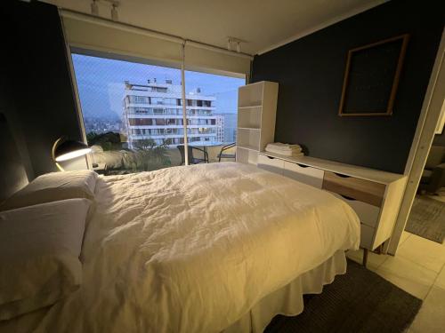 圣地亚哥Oceana Suites Capital, vista a la ciudad的卧室设有白色的床和大窗户