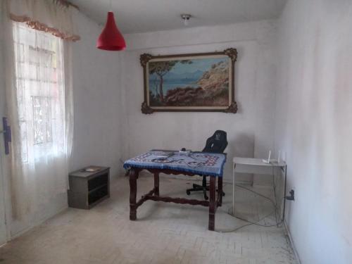 维多利亚Hostel Leonardo 10 Estrelas的一间墙上挂着一张桌子和一张照片的房间