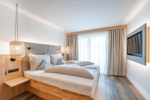 隆高地区圣玛格丽滕Löckerwirt的一间卧室配有一张大床和电视