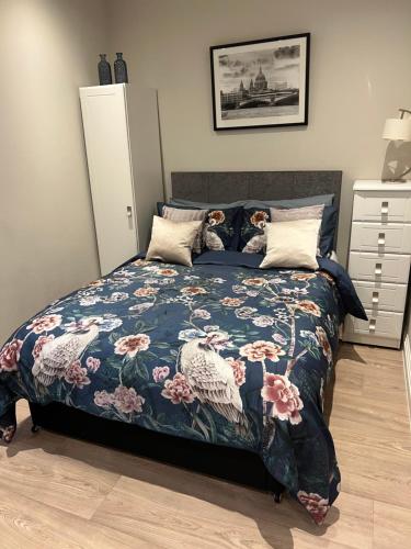 里克曼斯沃斯Sweet Swan House的一间卧室配有一张带花卉床罩的床