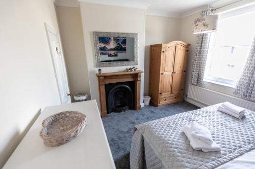 科尼斯顿Stunning Holiday Home - Puddleduck - Centre of Coniston的一间卧室配有一张床和一个壁炉