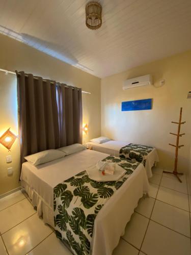 巴雷里尼亚斯Pousada Do Porto的酒店客房设有两张床和一张桌子。