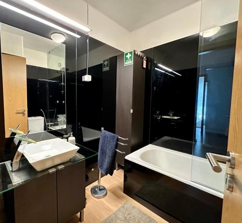 里斯本Olivais Spacious Apartment near airport的带浴缸、水槽和浴缸的浴室