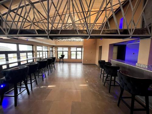 拉各斯Ikeja Airport View的大房间设有椅子,酒吧设有蓝色的灯光