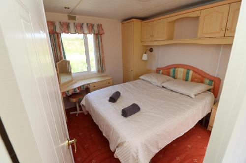 WolphaartsdijkDe Zuidvliet Chalet 4的小卧室配有床和2拖鞋