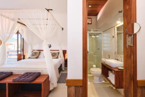 乌巴图巴Pousada Ubatuba Flats的一间卧室配有一张床,浴室设有水槽
