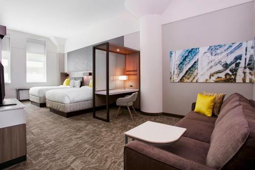 密尔沃基密尔沃基市中心万豪春季山丘套房酒店的酒店客房设有一张沙发和一张床