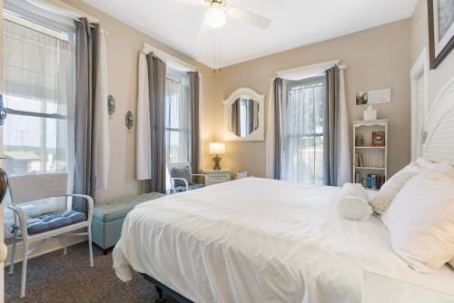 布兰森Historic Branson Hotel - Quiet Quilt Room with King Bed - Downtown - FREE TICKETS INCLUDED的卧室设有白色大床和窗户。