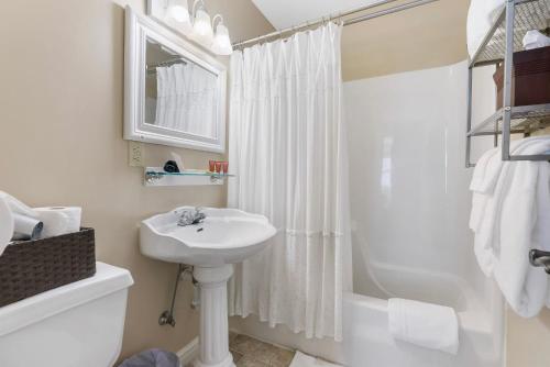 布兰森Historic Branson Hotel - Quiet Quilt Room with King Bed - Downtown - FREE TICKETS INCLUDED的白色的浴室设有水槽和淋浴。