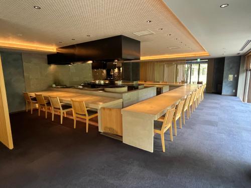 Jozankei廚翠山旅館的厨房设有长条酒吧,配有木桌和椅子