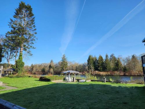 坎贝尔河Campbell River Lodge的一个带野餐桌和湖泊的大院子