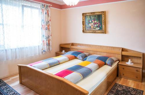 里格斯堡Ferienwohnung Familie Hartinger的一间卧室配有带色彩缤纷枕头的床