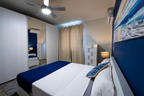 格兰贝伊Preety Blue Residence villas的蓝色和白色的卧室配有床和吊扇