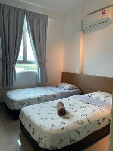 峇六拜Spice Arena Guesthouse的一间卧室设有两张床和窗户。