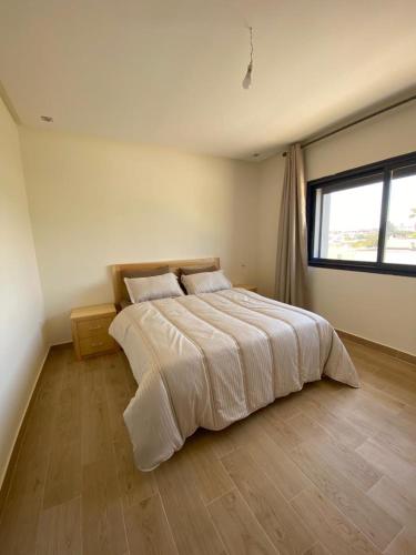 杰迪代appartement S-oumaima 2 el jadida的一间卧室设有一张大床和一个窗户。