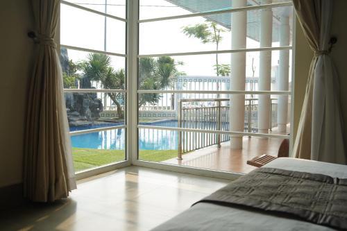 朗姑村Hà Phương Homestay的一间卧室设有大窗户,享有游泳池的景色