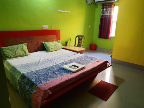 科纳卡Goroomgo Sun Plaza Lodge konark的一间卧室设有一张带绿色墙壁的床