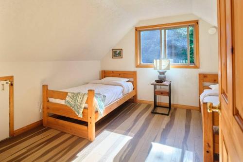帕克伍德Mountain View Cabin, Hot Tub at White Pass, Mt Rainier National Park的一间卧室设有一张床和一个窗口