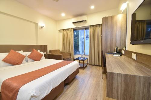 孟买Hotel Atlantic的酒店客房,配有床和电视