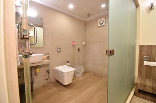 孟买Hotel Atlantic的一间带卫生间、水槽和镜子的浴室