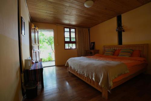 香格里拉香格里拉龙门客栈的一间卧室配有带橙色床单的床和窗户。