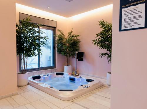 伯利恒Dar Al Mauge Boutique Hotel with Outdoor Pool的一个带按摩浴缸的植物客房