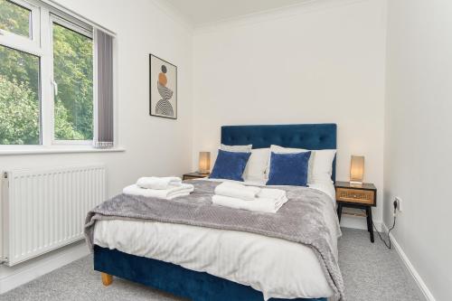 文特诺Stunning 3 Bed Apt With Countryside Views & Parking - Ideal For Families, Groups & Business Stays - Close To Ventnor, Shanklin & Sandown的卧室配有蓝色和白色的大床