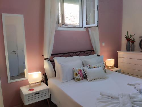 贝尼蔡斯Jo's Guesthouse, Benitses的卧室配有白色的床、窗户和镜子