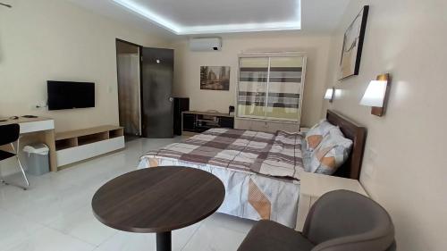 杜马格特Villa Shangri-La的一间卧室配有一张床、一张桌子和一张书桌