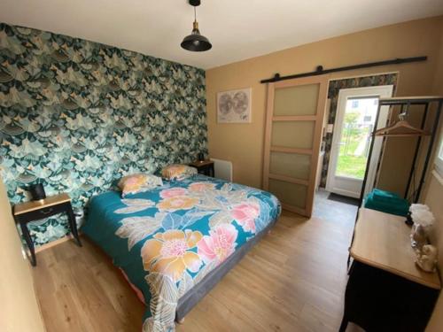 沙托鲁La Maison Passageon, Tout confort的一间卧室配有一张带花卉壁纸的床