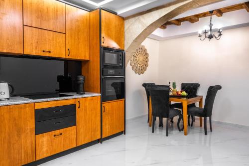 罗德镇Odysseus Luxury House的厨房配有木制橱柜和桌椅