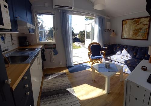 LyckeTofte Guesthouse nära hav, bad och Marstrand的厨房以及带沙发和桌子的客厅。
