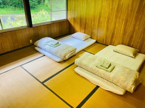 真庭市Yubara Hot Springs - Beautiful Riverside Hideaway的带2扇窗户的客房内的2张床