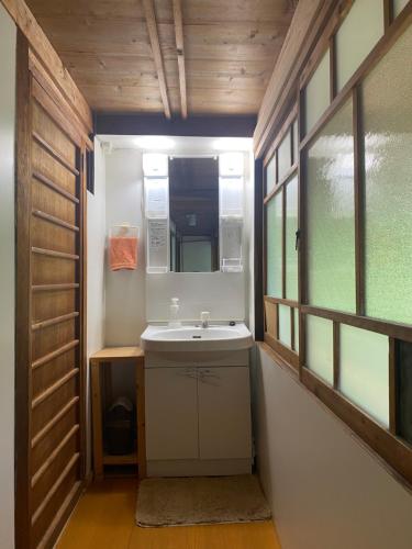 真庭市Yubara Hot Springs - Beautiful Riverside Hideaway的一间带水槽和镜子的浴室