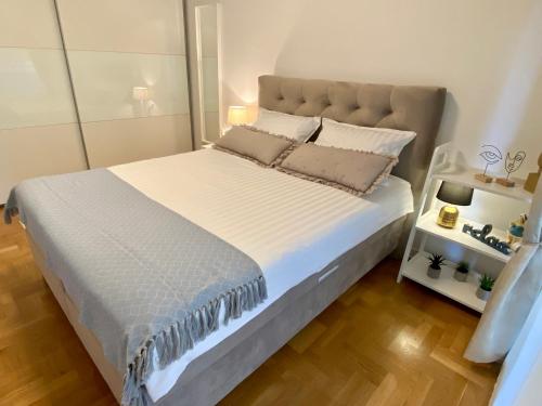 乌马格Apartment Eda - feels like home的卧室配有一张带白色床单和枕头的大床。