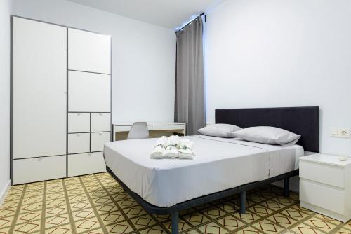 卡斯特利翁-德拉普拉纳Bieti Castellon的一间卧室,床上有两双白鞋