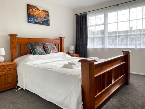 奥克兰Ali Motel的一间卧室设有一张大木床和窗户