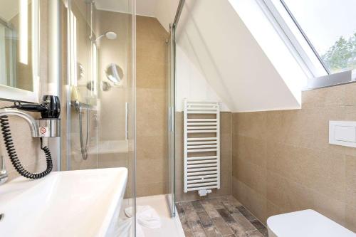 诺德奈Hotel Südblick的带淋浴、盥洗盆和天窗的浴室