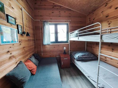 韦茨泽基斯韦斯基Cudnie tu - Noclegi na Kaszubach的小木屋内一间卧室配有双层床