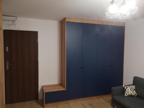 沃姆扎Małe mieszkanie的客厅配有蓝色橱柜和沙发