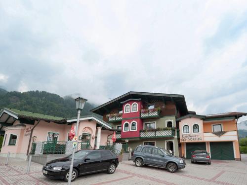 戈尔德格Idyllic holiday home in Goldegg Weng near ski bus的两辆汽车停在大楼前的停车场