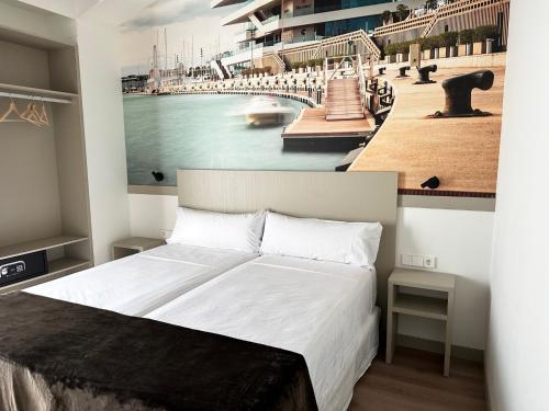 瓦伦西亚Hotel BESTPRICE Valencia的一间卧室配有一张大床,画着海港