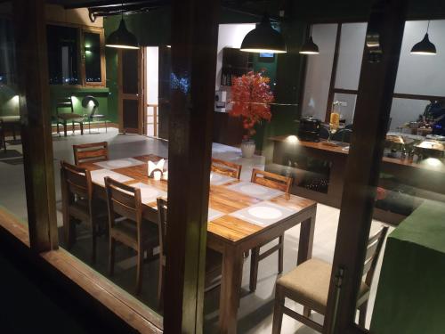 列城Maple house ladakh的一间带木桌和椅子的用餐室