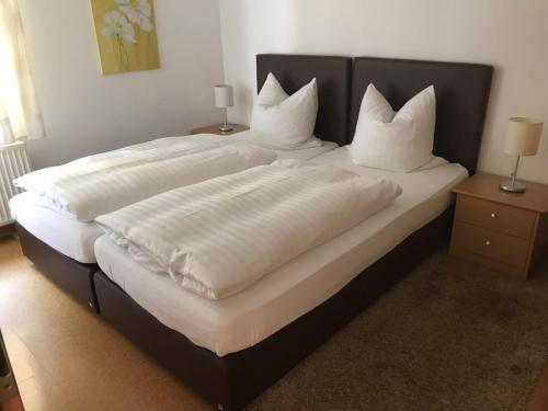 NiedersalweyLandhaus Kraehenberg的一间卧室配有两张带白色床单和枕头的床。